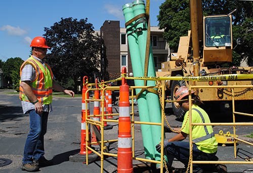 Two workers in safety vests near a blocked-off construction area.