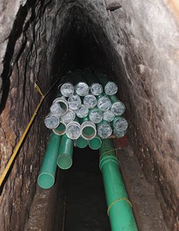 Green pipes in the middle of a sandstone arch.