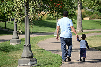 Parent and child walking hand-in-hand.