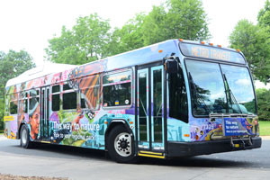 Metro Transit bus decorated with a person, butterfly, and flowers.