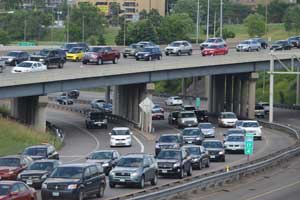 A highway crowded with vehicles on a bridge over another highway crowded with vehicles.