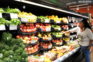 A shopper picking out fruit in a grocery store.