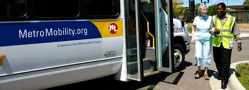 Driver helping rider get on bus