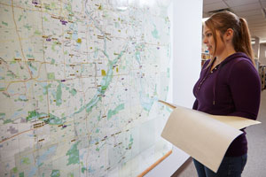 A planner studying a large map on a wall.