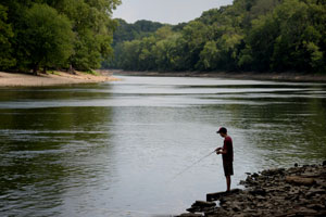 A child fishes in the Mississippi River below the Ford Dam.