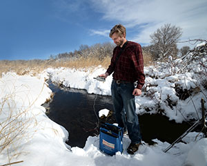 A staff member monitors the water quality in Seneca Fen.
