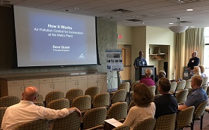 Color photo of community members viewing a presentation on the project at a public meeting.