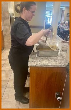Woman dishes soup into bowls at kitchen counter.